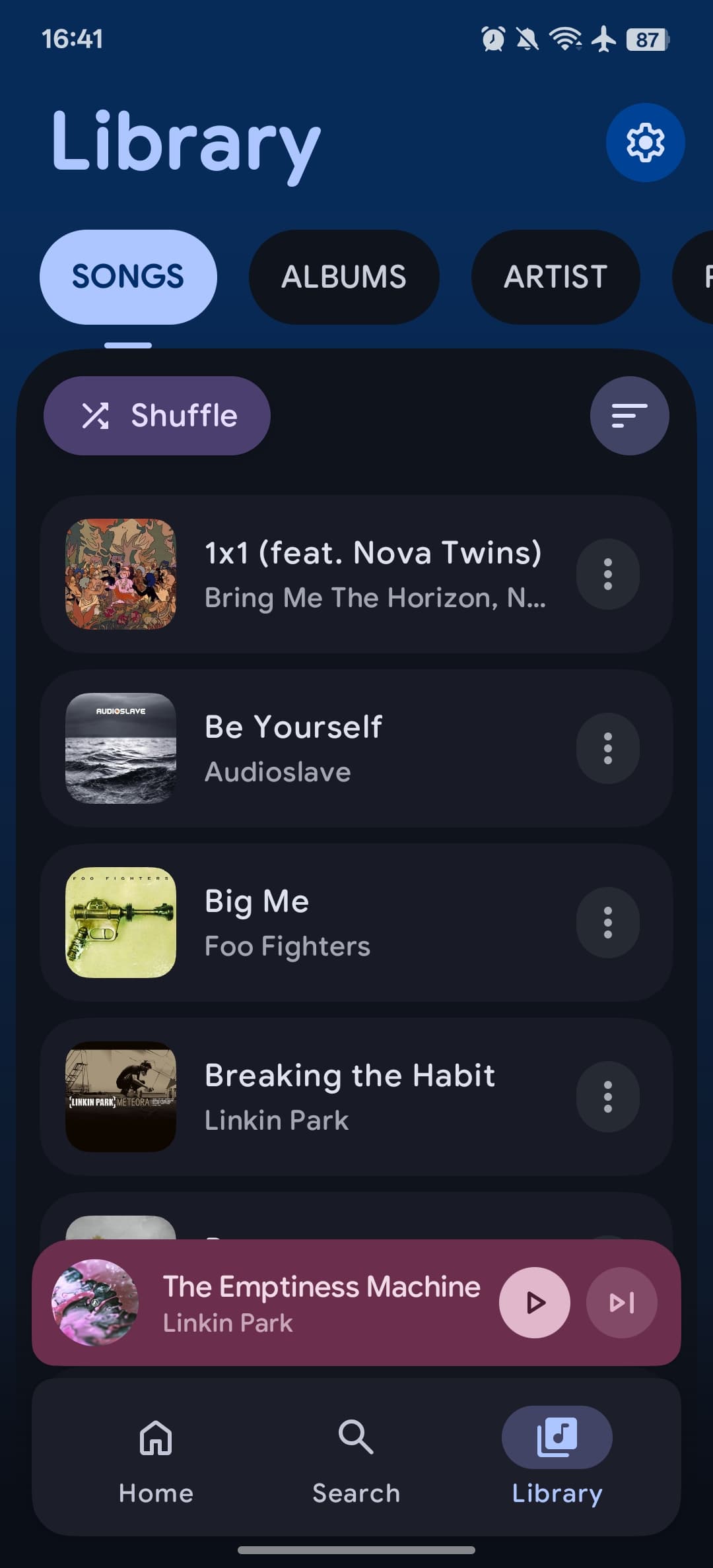 Aro Library showing local songs, album artwork, and a shuffle control